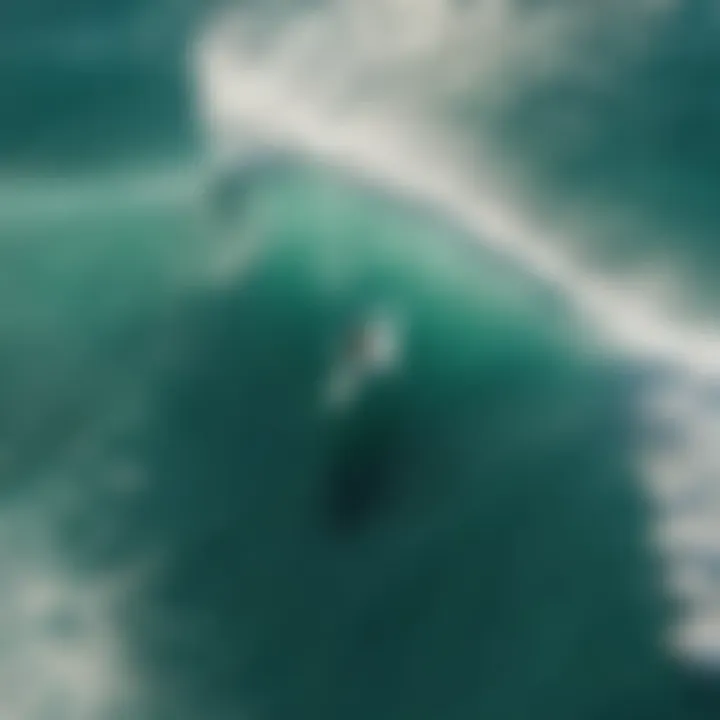 Aerial view of wakesurfer carving waves with foil board in turquoise ocean