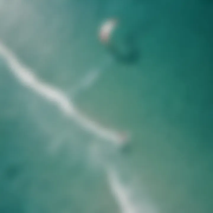 Aerial view of kitesurfers gliding gracefully over the crystal-clear waters of Aruba