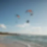 A panoramic view of a serene cat island beach with kitesurfers in the distance, showcasing vibrant waters and clear skies.