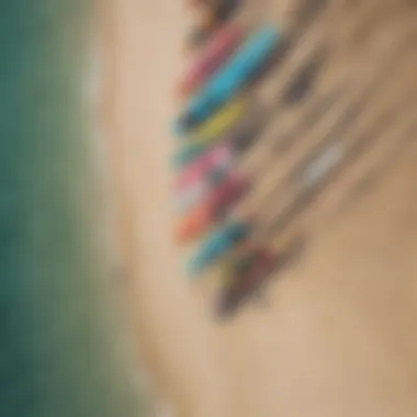 Aerial view of colorful kiteboards lined up on a sandy beach