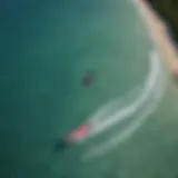 Aerial view of kiteboarder performing a trick over turquoise waters