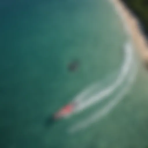 Aerial view of kiteboarder performing a trick over turquoise waters