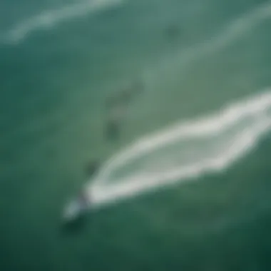 An aerial view of kitesurfers navigating the waves, highlighting the dynamic ocean conditions