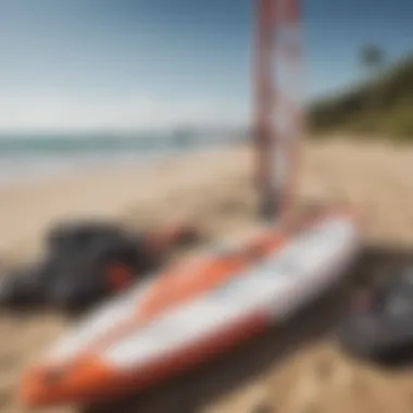 Windsurfing equipment laid out on a sandy beach