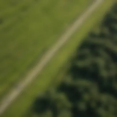 Aerial view of land boarder carving through lush green meadows