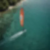 Aerial view of a kiteboarder gliding across crystal clear water