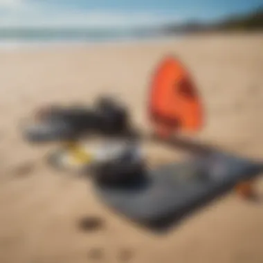 Essential kitesurfing equipment laid out on the beach, including a kite and board