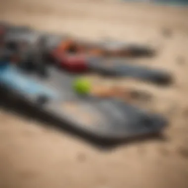 Close-up of kitesurfing gear laid out on the beach including a kite and board