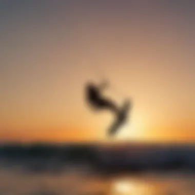 Sunset silhouette of a kitesurfer riding the waves