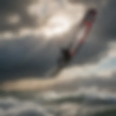 Silhouette of a kiteboarder carving through the wind against a dramatic cloudy sky