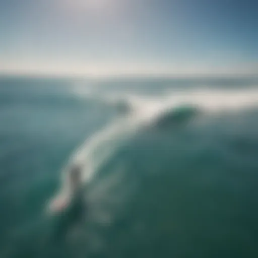 Aerial view of kitesurfers riding waves under a clear blue sky