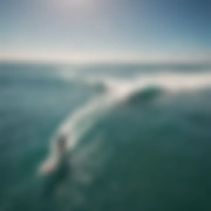 Aerial view of kitesurfers riding waves under a clear blue sky