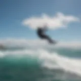 A mesmerizing aerial view of a kitesurfer riding the waves under a clear blue sky