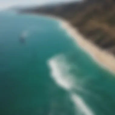 Aerial view of kite surfer gliding over turquoise waters