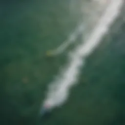 Aerial view of kitesurfers riding the waves with colorful kites